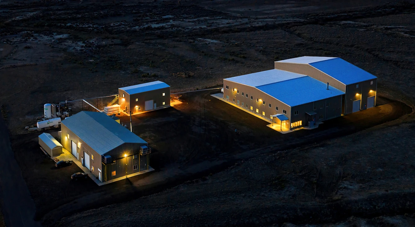 Aerial view of the Conductive Composites facility in Cleveland, Utah, its buildings lit at dusk